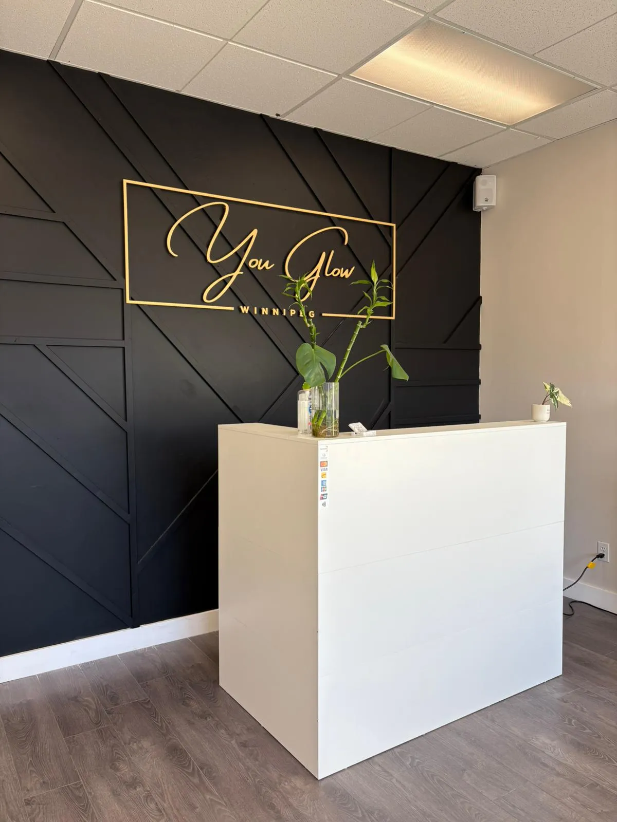 You Glow Winnipeg front desk with black feature wall